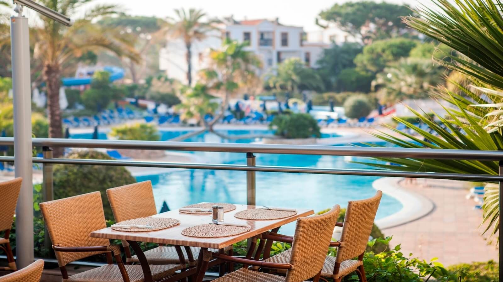 Scenic dining area overlooking the pool at Alfagar I Village, providing a relaxing atmosphere for guests to enjoy meals with beautiful views.