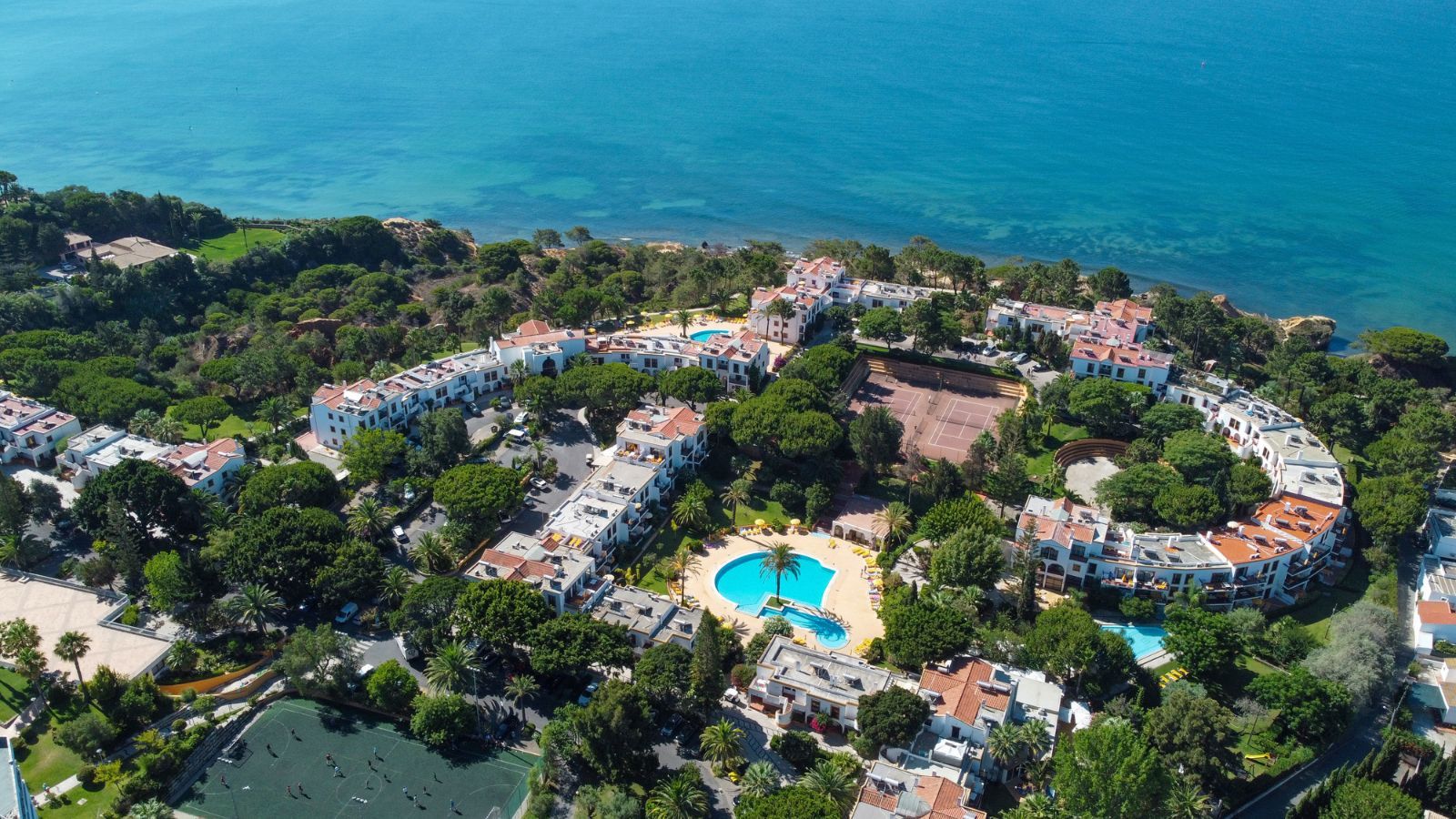 Aerial view of Alfagar I Village showcasing its extensive resort facilities including pools, tennis courts, and lush greenery along the coastline.
